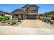 Beautiful two-story home showcasing a well-manicured front yard and brick driveway at 33275 N 132Nd Ave, Peoria, AZ 85383