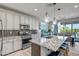 Spacious kitchen with stainless steel appliances, granite countertops, island with seating, and adjacent dining area at 33275 N 132Nd Ave, Peoria, AZ 85383