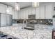 Close up of kitchen island with granite countertops, stainless steel appliances, and herringbone tile backsplash at 33275 N 132Nd Ave, Peoria, AZ 85383