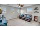 Comfortable living room with natural light, plush seating, ceiling fan, and a cabinet for media storage at 33275 N 132Nd Ave, Peoria, AZ 85383