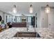 Contemporary open-concept living area featuring a large island, comfortable seating, and modern light fixtures at 33275 N 132Nd Ave, Peoria, AZ 85383