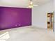 Bedroom with a bold purple accent wall and a ceiling fan at 3417 W Abraham Ln, Phoenix, AZ 85027