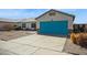 Inviting single-story home featuring a vibrant turquoise garage door and well-kept landscaping at 3417 W Abraham Ln, Phoenix, AZ 85027