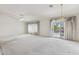 Spacious living room with carpet, decorative chandelier, and sliding glass doors to the backyard at 3417 W Abraham Ln, Phoenix, AZ 85027