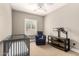 Neutral bedroom with a crib, chair, shelving, and plantation shutters at 3528 E Decatur St, Mesa, AZ 85213