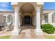 Stunning front entryway with an arched portico supported by white pillars leading to a large double door at 3528 E Decatur St, Mesa, AZ 85213