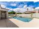 Backyard pool and spa with rock feature, green turf, and beige decking at 3528 E Decatur St, Mesa, AZ 85213
