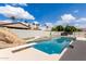 Backyard swimming pool featuring diving board, rock waterfall, and spa with palm trees in background at 3528 E Decatur St, Mesa, AZ 85213