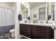 Bathroom featuring double sinks with dark wood cabinets, large mirrors, and neutral colors at 3855 S Mcqueen Rd # 24, Chandler, AZ 85286