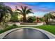 Backyard oasis featuring a trampoline, mature palm trees, artificial turf, and decorative landscaping at 4055 N Recker Rd # 82, Mesa, AZ 85215