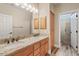 Bright bathroom with double sinks, granite counters, wood floors, and glass-enclosed shower at 4055 N Recker Rd # 82, Mesa, AZ 85215