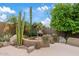 Cozy outdoor fireplace featuring a stucco surround, desert landscaping, and a seating area for intimate gatherings at 4055 N Recker Rd # 82, Mesa, AZ 85215