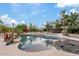 Backyard swimming pool with water features, lush landscaping, and blue skies overhead at 4055 N Recker Rd # 82, Mesa, AZ 85215