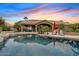 Backyard pool reflecting the sunset, lounge chairs, desert landscaping, and a covered patio with seating at 4055 N Recker Rd # 82, Mesa, AZ 85215