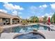 A large swimming pool and hot tub are surrounded by a patio and lush greenery for the ultimate backyard experience at 4055 N Recker Rd # 82, Mesa, AZ 85215