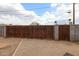 This backyard features a wooden gate, gravel, a block wall, and perimeter sidewalks at 4117 W Sierra Vista Dr, Phoenix, AZ 85019