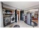 Functional laundry room with side by side appliances and open shelves for storage at 4117 W Sierra Vista Dr, Phoenix, AZ 85019