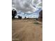 Wide view of a vacant lot with a walkway on one side, adjacent to residential buildings under a partly cloudy sky at 4219 N 69Th N Ln # 1319, Phoenix, AZ 85033