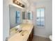 Bright bathroom featuring wood vanity, a large mirror, and window allowing natural light at 4247 N 101St Ave, Phoenix, AZ 85037