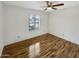 This room features a ceiling fan, window, wood-look flooring, offering a blend of comfort and style at 4247 N 101St Ave, Phoenix, AZ 85037