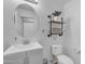 Charming half-bathroom featuring a round mirror, stylish shelves with decor, and modern fixtures at 4559 E Sierrita Rd, San Tan Valley, AZ 85143