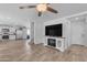 Open-concept living room with tile flooring, white walls, and a modern entertainment center with an electric fireplace at 4559 E Sierrita Rd, San Tan Valley, AZ 85143