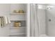 Bright bathroom featuring shelving and decor, alongside a shower with a modern shower curtain at 5016 S 106Th Ln, Tolleson, AZ 85353