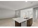 Kitchen island featuring a sink with view into a large and bright living area at 5053 S 252Nd Ave, Buckeye, AZ 85326