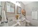 Bathroom with double sinks, framed mirrors, and a decorative wall basket for storage at 512 W Seldon Ln, Phoenix, AZ 85021
