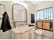 Nicely decorated bathroom featuring a vanity, framed mirror, and window with patterned curtains at 512 W Seldon Ln, Phoenix, AZ 85021