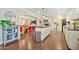 Bright, open kitchen featuring white cabinets, an island, stainless steel appliances, and wood flooring at 512 W Seldon Ln, Phoenix, AZ 85021