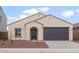 Charming single-story home with a dark gray garage door, landscaped front yard, and classic Southwestern architecture at 5201 S 251St Dr, Buckeye, AZ 85326
