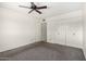 Bedroom featuring a ceiling fan, carpet, closet with white doors, and neutral walls at 5203 W Acoma Dr, Glendale, AZ 85306