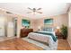 Bright bedroom featuring hardwood floors, a ceiling fan, modern decor, and a neutral color scheme at 5203 W Acoma Dr, Glendale, AZ 85306