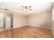 Large bedroom with wood floors, ceiling fan, and view to the en suite bathroom at 5203 W Acoma Dr, Glendale, AZ 85306
