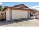 View of the two car garage on a single-story home with mature landscaping at 5203 W Acoma Dr, Glendale, AZ 85306