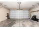 A large garage with a finished ceiling, a white door, and concrete flooring at 5203 W Acoma Dr, Glendale, AZ 85306