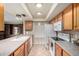 Well-lit kitchen with granite countertops, wood cabinets, and updated appliances at 5203 W Acoma Dr, Glendale, AZ 85306