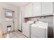 Laundry room with white washer and dryer, upper cabinets, and a back door at 5203 W Acoma Dr, Glendale, AZ 85306
