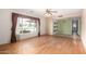 Open living room with wood floors, large window and view into other rooms at 5203 W Acoma Dr, Glendale, AZ 85306