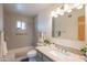 Well-lit bathroom featuring a granite countertop, large mirror, and a shower-tub combo with modern fixtures at 5401 E Cicero St, Mesa, AZ 85205