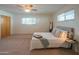An inviting bedroom with plush carpeting and a cozy bed is illuminated by natural light at 5401 E Cicero St, Mesa, AZ 85205