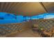 Cozy covered patio with decorative concrete block wall, and seating area at dusk at 5401 E Cicero St, Mesa, AZ 85205