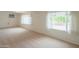 Spacious living room with plush carpet, large windows and neutral colors, creating a cozy atmosphere at 5401 E Cicero St, Mesa, AZ 85205
