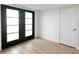 Bright bedroom featuring minimalist decor, French doors, and wood-look flooring at 5564 N 77Th Pl, Scottsdale, AZ 85250