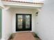Inviting home entrance highlighting a red brick walkway leading to black, glass-paneled double doors at 5564 N 77Th Pl, Scottsdale, AZ 85250