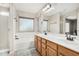 Bathroom featuring a dual sink vanity, framed mirror, tub, and shower at 6539 W Briles Rd, Phoenix, AZ 85083