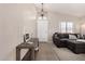 Bright foyer featuring tile floors, a modern desk, and a comfortable gray couch in the living area at 6539 W Briles Rd, Phoenix, AZ 85083