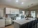 Bright kitchen featuring white cabinetry, a quartz countertop island with seating, and stainless steel appliances at 6539 W Briles Rd, Phoenix, AZ 85083