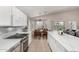 Modern kitchen boasts white cabinets, an island, and is open to the dining area at 6539 W Briles Rd, Phoenix, AZ 85083